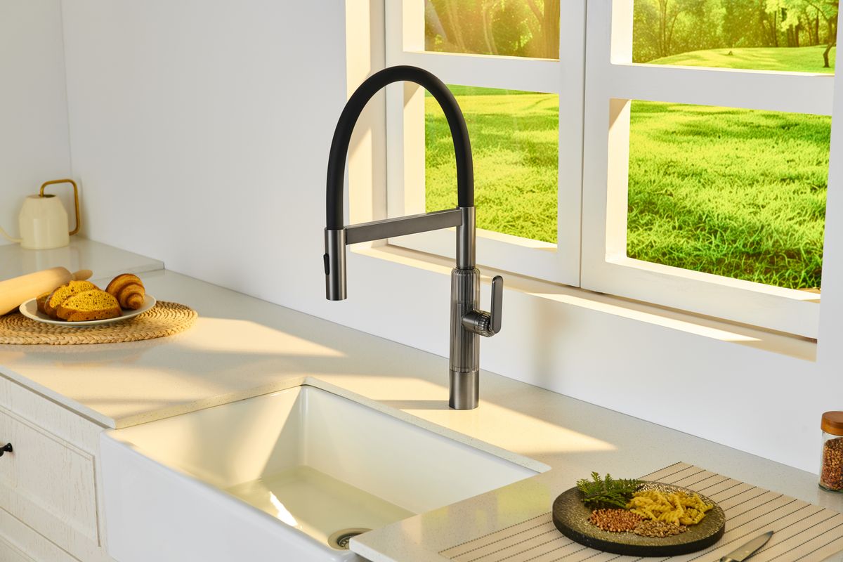 Black kitchen faucet and sink beside a window