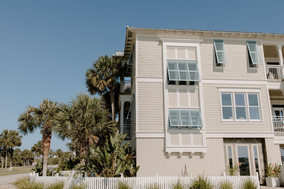 White-sided house with palms alongside