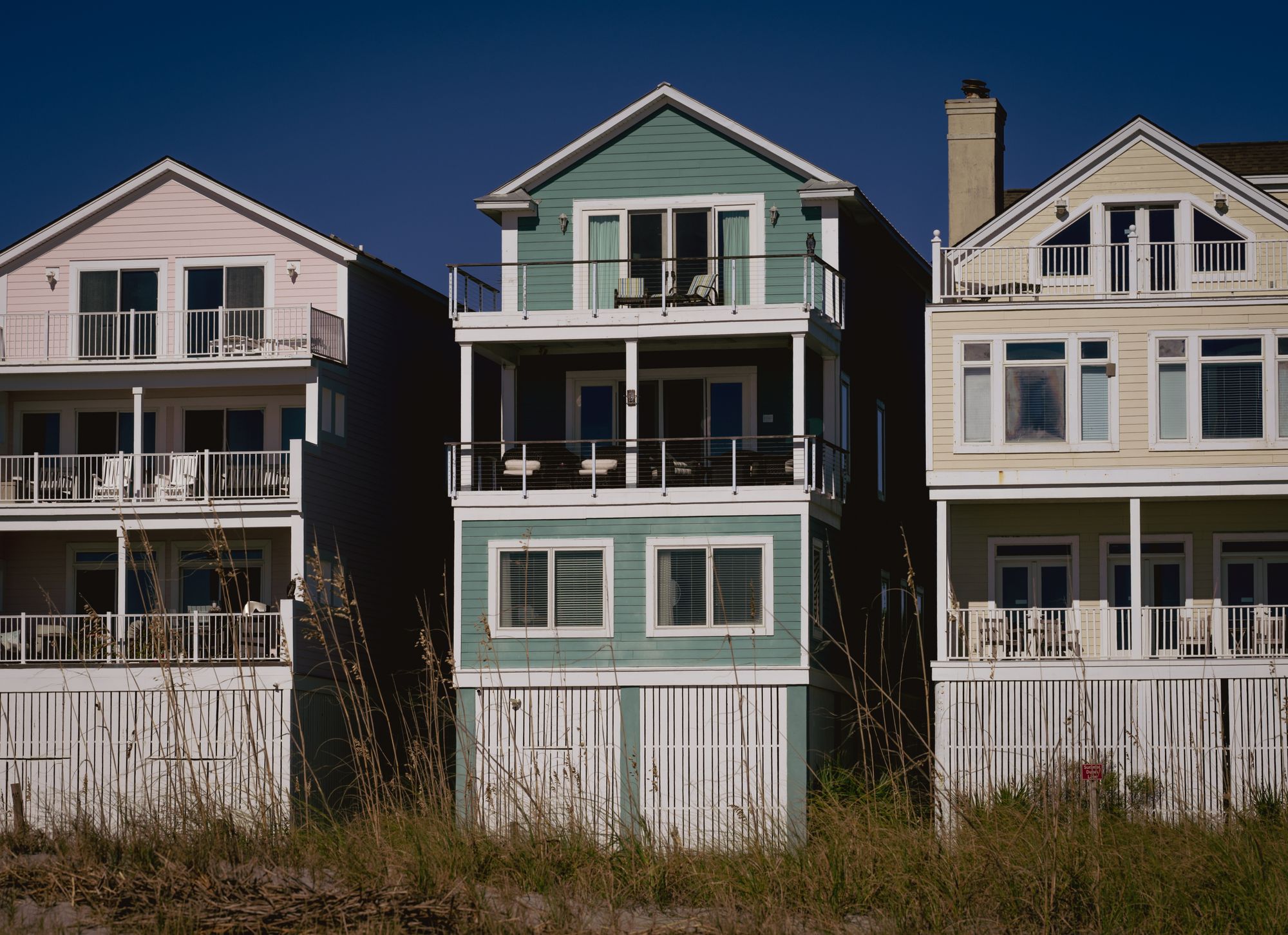 Wood-sided coastal houses under a clear sky